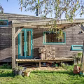 Wooden Detached Villa With Covered Porch Green Door And Grass Surrounding Trees