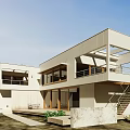 Modern Single Family House Exterior With Balcony Large Windows Wooden Accents Concrete Stairs And Greenery