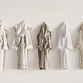 Different Colored Robes Hanging on Hangers Against Light Wall Background