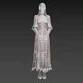 Woman in light colored long dress wearing glasses with hands crossed standing against black background