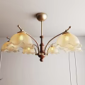 Vintage Glass Chandelier with Scalloped White Shades and Brown Metal Frame Hanging in Light Room