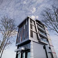 Modern High Rise Office Building with Glass Curtain Wall Surrounded by Trees Under Blue Sky