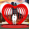 Red Heart Shaped Sculpture With Two People And City Night Skyline