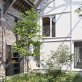 Serene Courtyard Garden With Red Brick Walls Glass Roof White Building And Stone Path