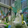 Floral Installation With Woman In White Dress Green Marble Waterfall Colorful Flowers And Curved Arch