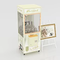 Gashapon Machine With Transparent Window Next To Easel Holding Decorative Picture Frame