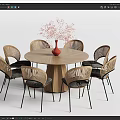Round Wooden Dining Table Set With Rattan Back Chairs Black Cushions Red Vase Pink Flowers