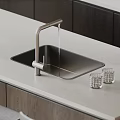 Modern Black Kitchen Sink With Brushed Nickel Faucet On Light Gray Countertop And Glass Tumblers