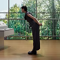 Woman Standing In Interior Space With Large Windows And Green Trees View