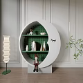 White Moon Shaped Decorative Cabinet With Green Trees Books Figurines Floor Lamp And Potted Plant