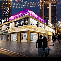 Modern Brightly Lit Commercial Street Storefronts With Warm Atmosphere In Busy Night Urban Pedestrian Block