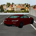 Red Sports Coupe Driving On Road With Industrial Concrete Building And Pipes