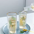 Clear Gold Rimmed Glasses With Ice Cubes Lemon Slices Mint Leaves On Light Blue Tray