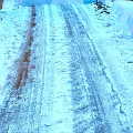 Snowy Winter Ground With Visible Tire Tracks And White Snow Cover