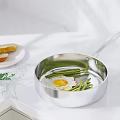 Fried Egg With Green Beans Cooking In Stainless Steel Pan And Bread On Marble Countertop