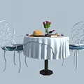 Wrought Iron Table and Chair Set with Round White Tablecloth Red Roses and Blue Cushions