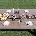 Outdoor Wooden Dining Table With Fruit Basket Candle Plates And Cutlery On Grass