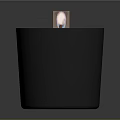 Lit Candle In Black Container With White Wax And Decorative Label