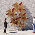 People Posing At Check in Photo Spot With Large Decorative Plant And Golden Red Leaves