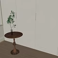 Round Wooden Side Table with Decorative Pedestal and Green Plant in Room Corner