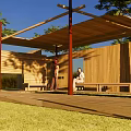 Wooden Pergola Featuring Shaded Roof And Benches On Green Lawn With Trees