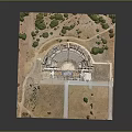 Ancient Stone Amphitheater Ruins Surrounded By Grass And Trees In Historical Site