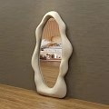 Modern Irregular Shaped Mirror With Cream Frame Reflecting Living Room Interior On Wooden Tabletop