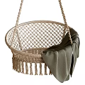 Natural Wicker Hanging Chair With Tassel Trim And Soft Green Blanket Accent