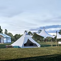 White Canvas Camping Tents In Outdoor Grassland With Pyramid Shape And Trees