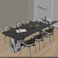 Modern Table And Chairs Set Black Top Mixed Chairs Open Book Fruit Tray Bright Room