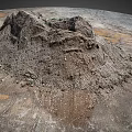 Large Dirt Mound With Gravel And Sparse Vegetation On Barren Ground With Tire Tracks