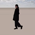 Woman Wearing Black Coat And Dark Pants Walking On Wooden Floor With Light Background