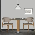 Wooden Round Table With Two Upholstered Chairs And Pendant Lamp Near Framed Wall Art On Rug