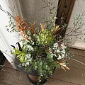 Decorative Black Vase With Green Plants Orange Blooms White Flowers And Twigs On Dark Table