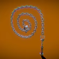 Silver Spiral Chain With Small Airplane Model And Hook On Orange Background 3d model
