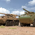 Two Tan And Green Armored Tanks On Sandy Terrain Under Blue Sky White Clouds