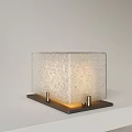 Square Frosted Glass Table Lamp With Metal Base And Soft Warm Light On White Tabletop