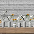White Brick Wall Background With Wooden Floor And Multiple White Vases Holding Orange White Flowers