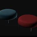 Two Round Upholstered Footstools in Blue and Red with Metal Legs on Black Background