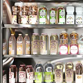 Assorted Bottled Beverages Displayed in Refrigerator with Various Flavors and Colors