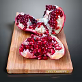 Fresh Sliced Pomegranate with Plump Red Arils on Wooden Cutting Board