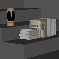 Gray Stepped Shelf Display With Various White Beige Books And Golden Humanoid Head Sculpture