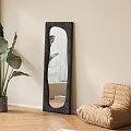 Full Length Irregular Black Mirror In Minimalist Interior With Plant And Bean Bag
