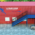 Red Container Emergency Shelter Building With Blue Stairs And Signage