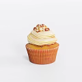 Delicious Cupcake With Swirled Vanilla Cream And Crushed Nuts On Orange Liner