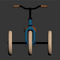 Blue Kids Tricycle With Brown Seat Orange Handlebars And Three Wheels On Black Reflective Surface