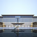 Grand Hotel Building Exterior With Traditional Chinese Roof Large Glass Windows And Water Pond Reflection