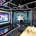 Modern KTV Lounge Interior With Large Screen Colorful Lighting Leather Sofa And Drinks