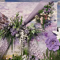 Outdoor Floral Installation With Purple White Flowers Green Grass And Blue Sky Backdrop
