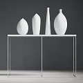 Four White Vases Arranged On Black Metal Frame Table Against Dark Gray Wall